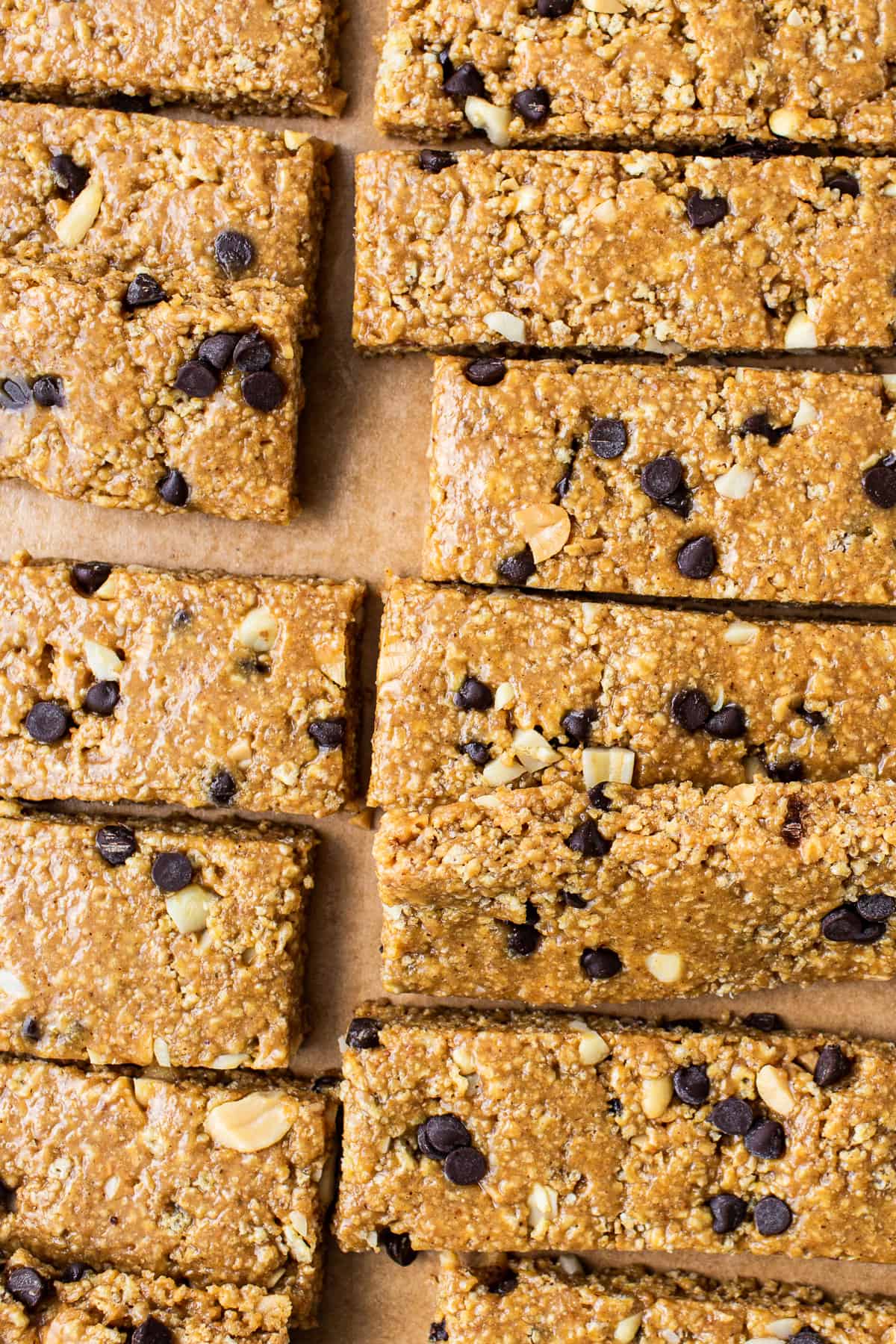 Want a healthy, protein-packed snack on the go? These no bake peanut butter bars will be your new favorite treat! They're crunchy, sweet, salty, and ridiculously easy to make. No bake peanut butter bars cut on parchment paper.