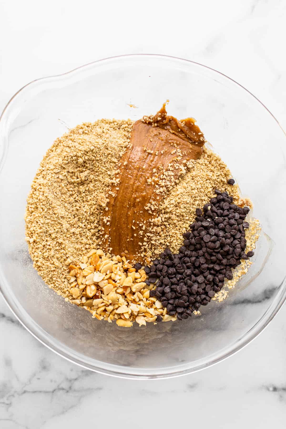 Want a healthy, protein-packed snack on the go? These no bake peanut butter bars will be your new favorite treat! They're crunchy, sweet, salty, and ridiculously easy to make. Ingredients for no bake peanut butter bars in a bowl.