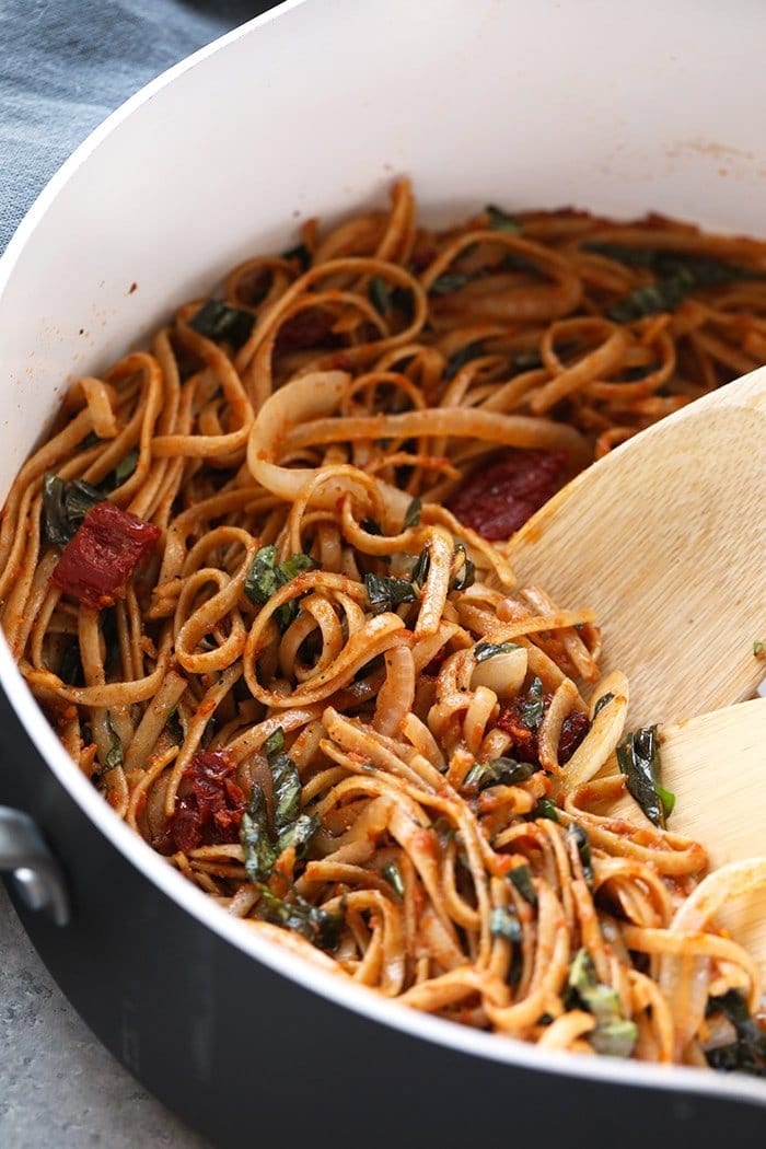 Pasta can be a healthy dinner packed with flavor and deliciousness. Substituting whole wheat pasta, adding vegetables, and creating a flavorful sauce is the key a healthy pasta for dinner. Treat yourself to this Whole Wheat Sun Dried Tomato Basil Pasta. It's light, fresh, and only require a few simple ingredients! sun dried tomato pasta with whole wheat noodles in pan