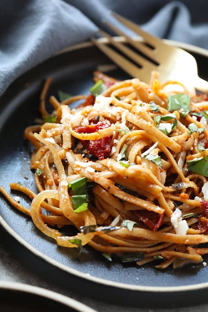 Pasta can be a healthy dinner packed with flavor and deliciousness. Substituting whole wheat pasta, adding vegetables, and creating a flavorful sauce is the key a healthy pasta for dinner. Treat yourself to this Whole Wheat Sun Dried Tomato Basil Pasta. It's light, fresh, and only require a few simple ingredients! whole wheat sun dried tomato pasta on plate