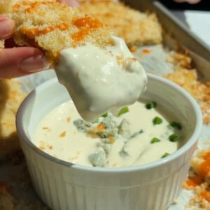 Chicken protein bars served with blue cheese dip garnished with fresh herbs and crumbled cheese