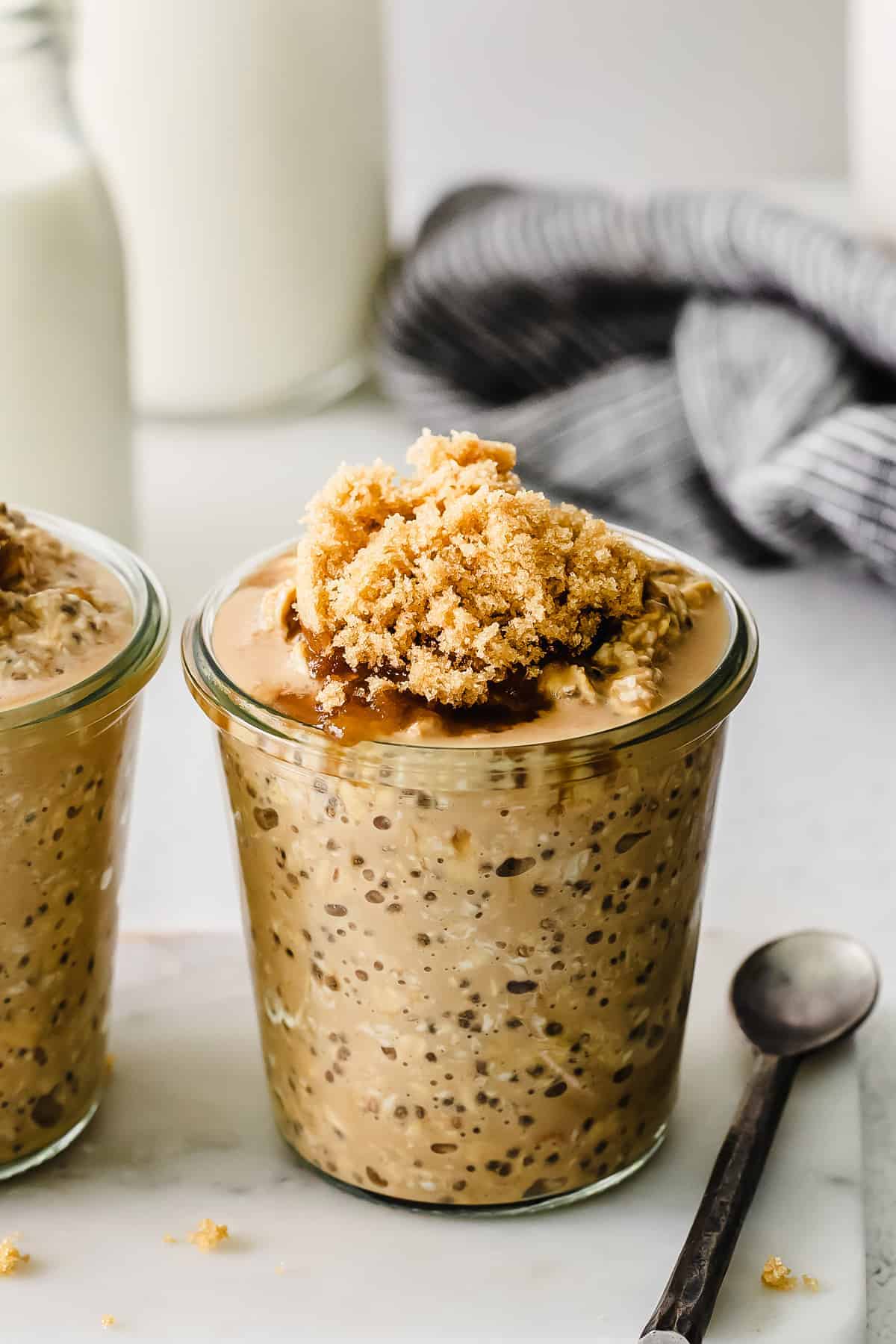 close-up of brown sugar shaken espresso overnight oats in a jar with a spoon showing creamy pudding-like texture