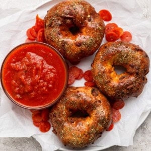 Pizza protein bagels with Italian seasoning served with marinara sauce and pepperoni slices