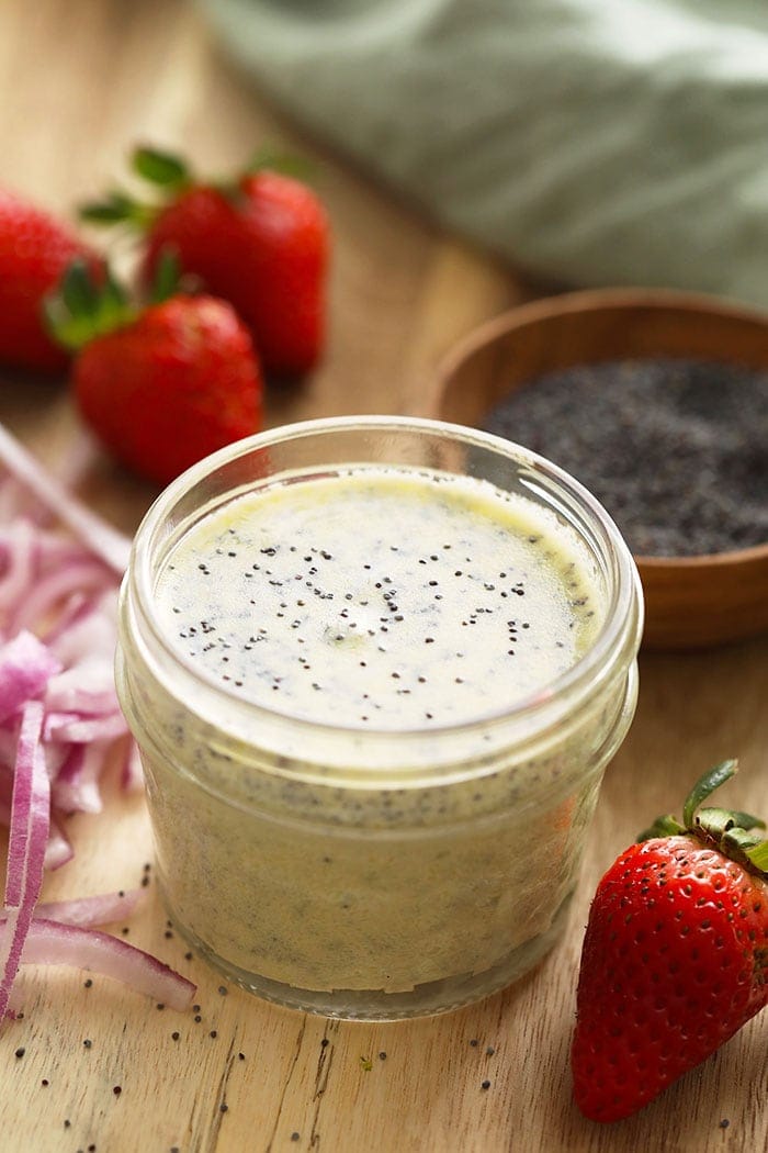A jar of homemade poppy seed dressing for strawberry spinach salad.