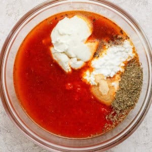 Tomato sauce, cottage cheese, and Italian seasonings in a glass bowl