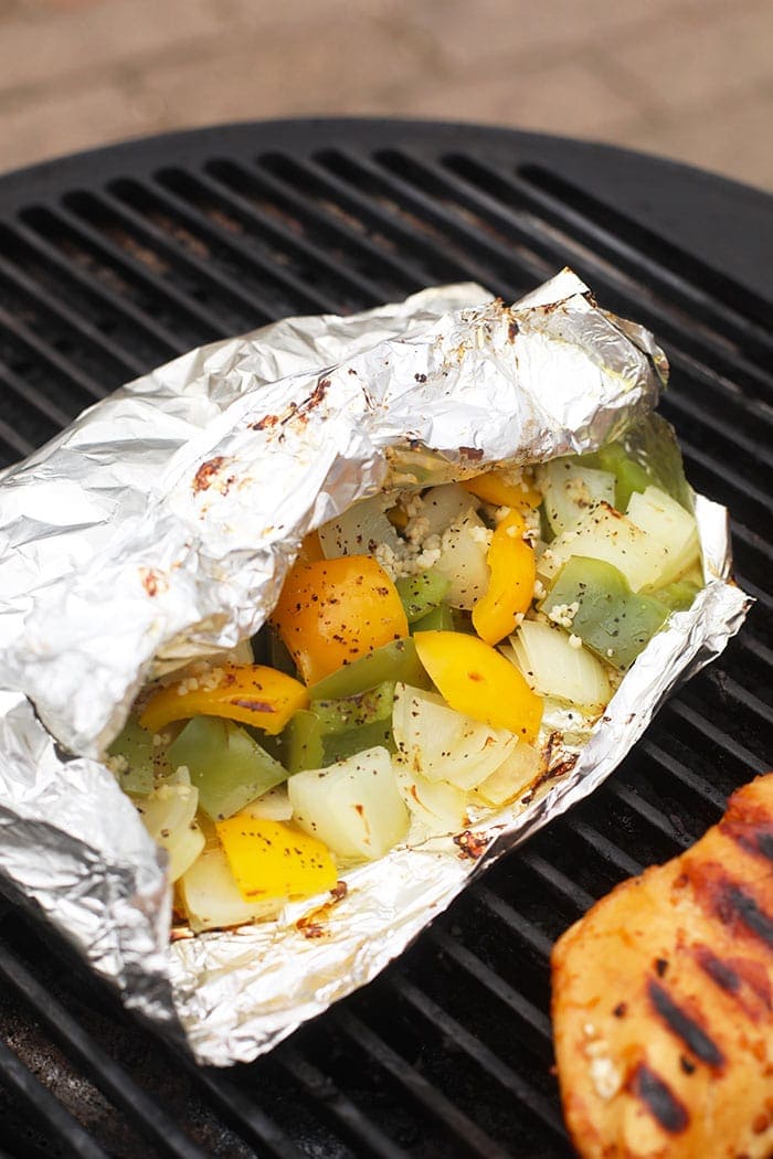 Grilled bell peppers and onions in a foil pack on the grill