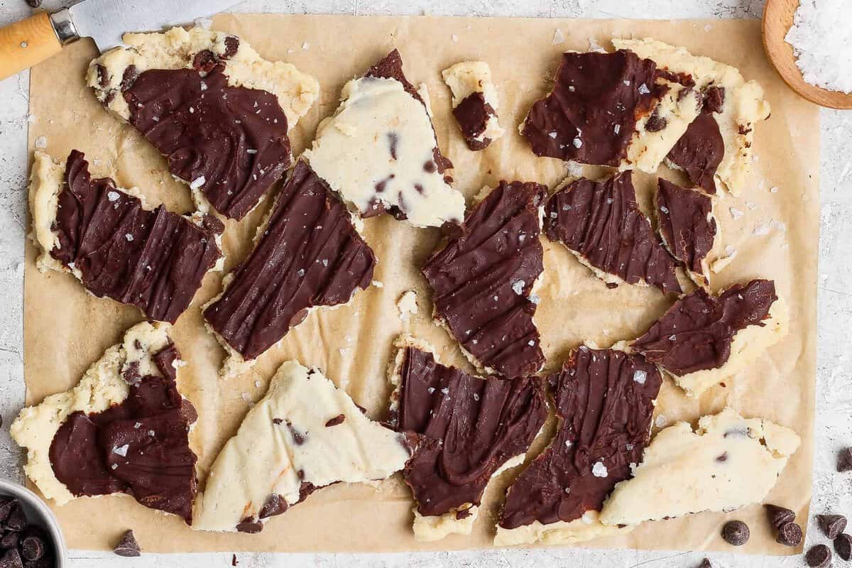 cottage cheese cookie dough bark broken into pieces on parchment paper
