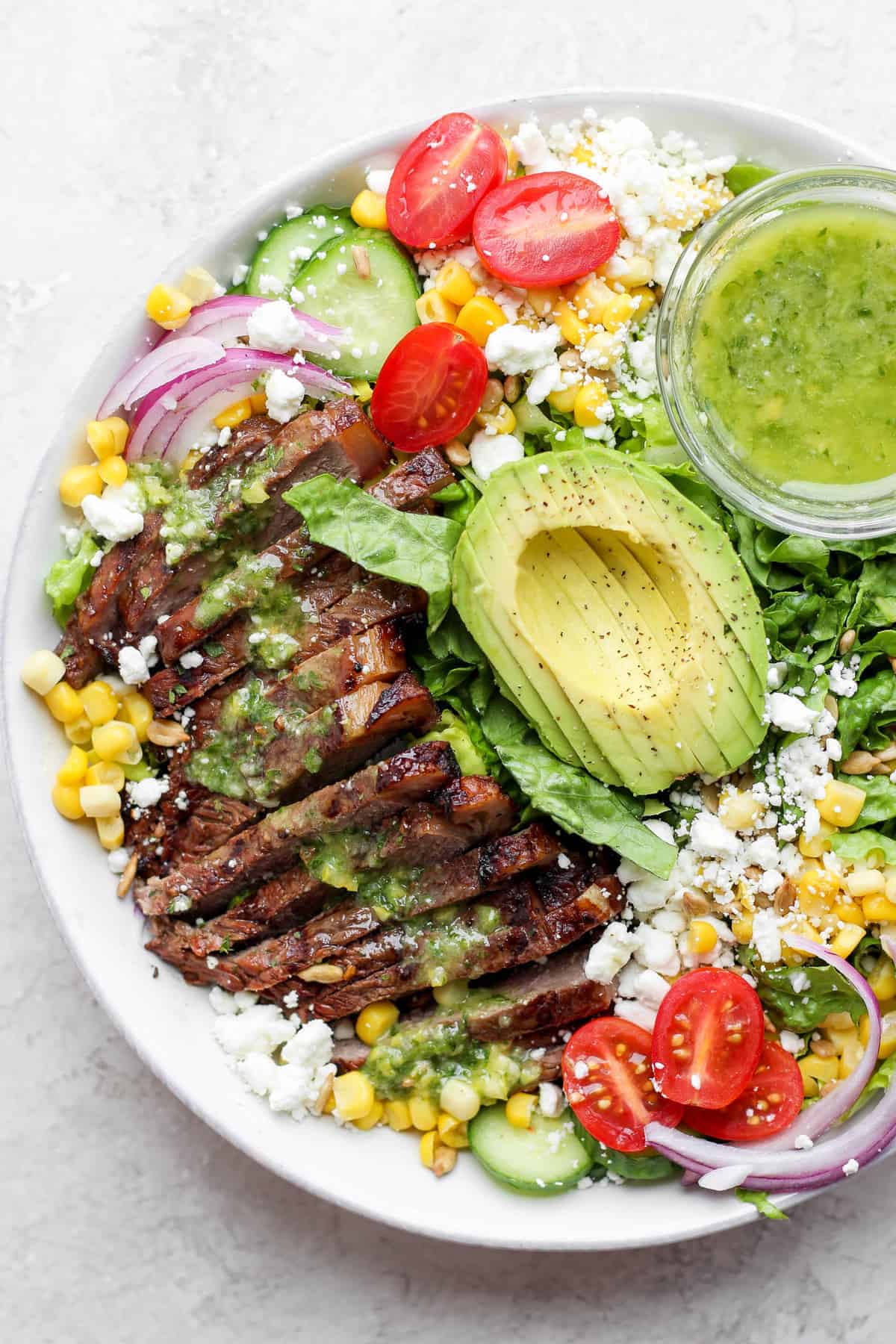 Seriously delicious steak salad made with perfectly grilled steak, avocado, tons of veggies, and an herby vinaigrette dressing. steak salad in bowl.