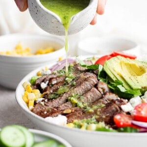 pouring dressing on salad.