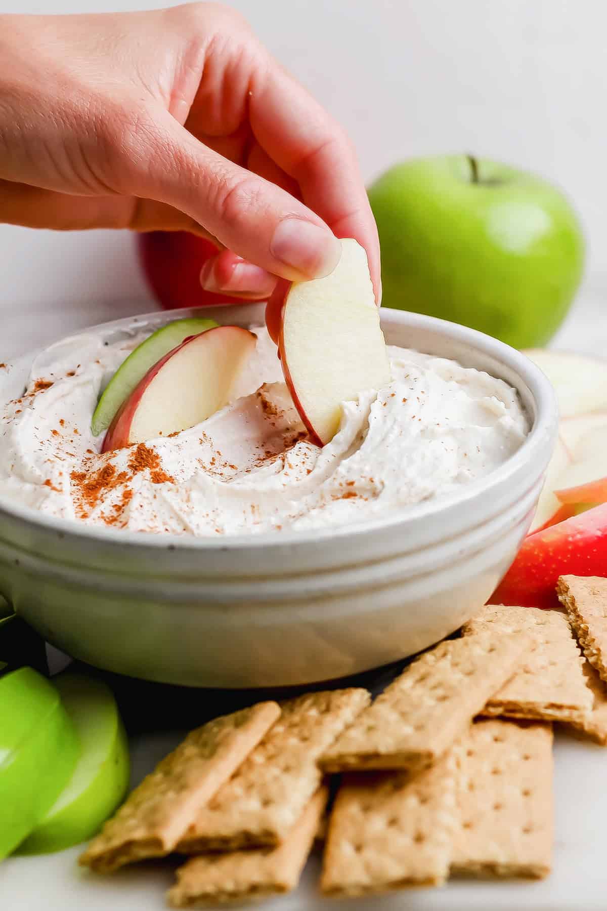 apple slice dipping into high-protein apple dip