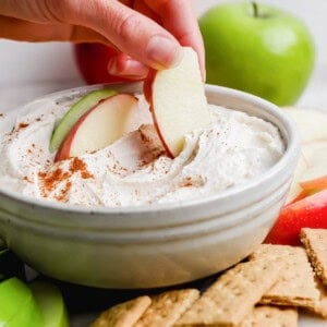 apple slice dipping into high-protein apple dip