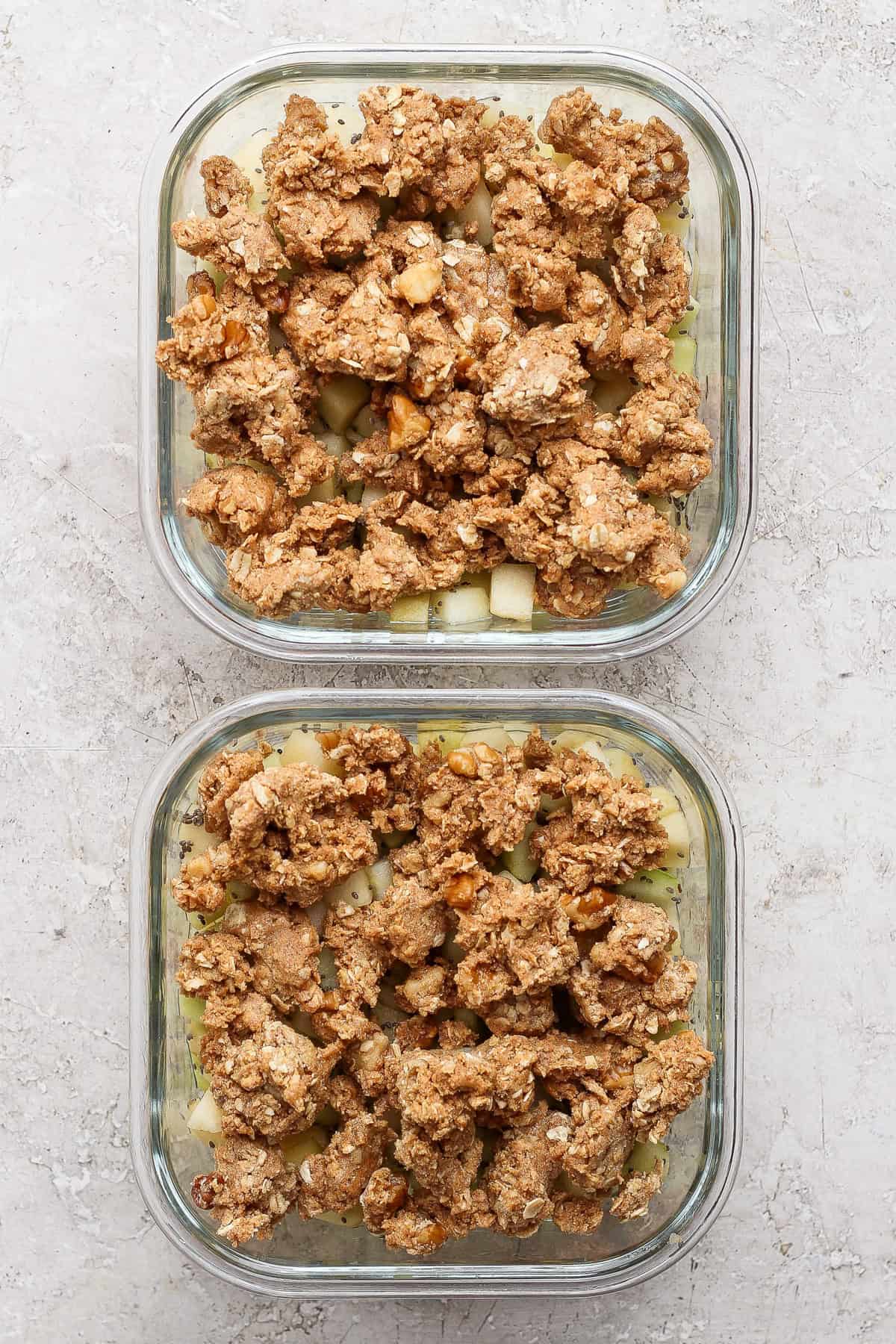 Unbaked protein apple crisp in two square glass meal prep containers.