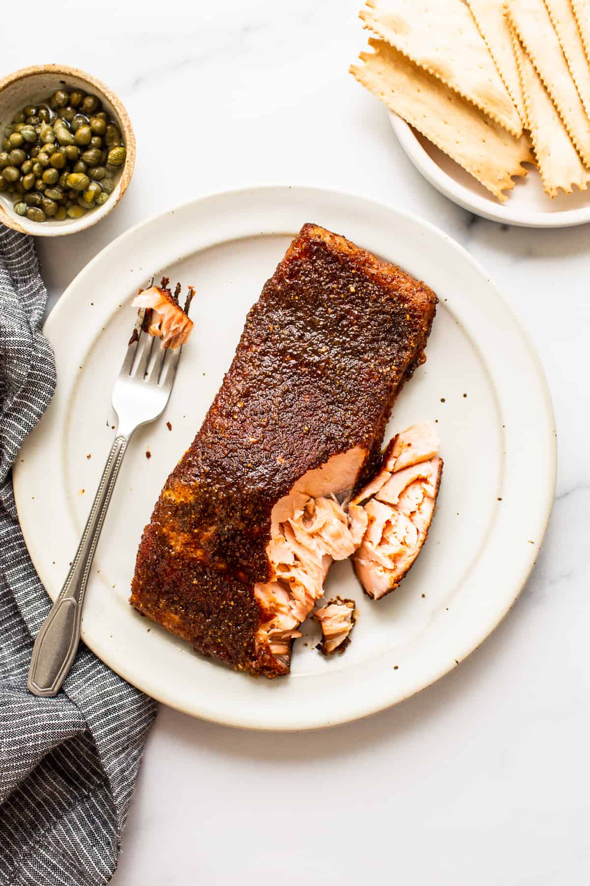Smoked salmon is such a delicious and nutritious appetizer. This smoked salmon recipe is made with a smoked salmon dry rub and yummy maple glaze. salmon on plate with fork.