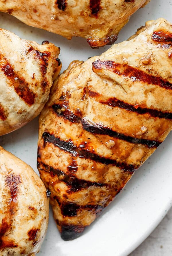 grilled chicken breasts on a white plate.